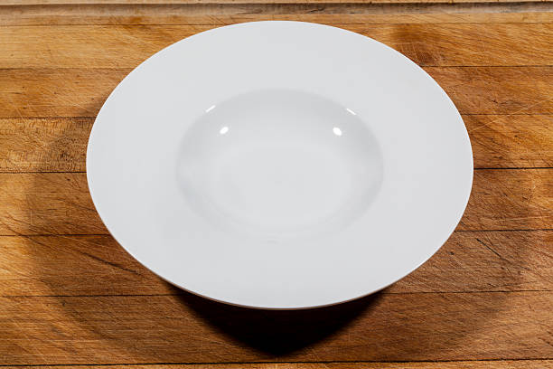 istock Deep soup plate with shoulders on cutting board from side 628895998