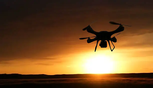 3d render quadrocopters silhouette in the background. radio-controlled toy is filming nature. Unmanned flying drone sunset
