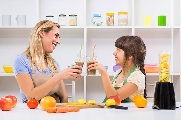 istock Mother and daughter making and drinking smoothies 628899790