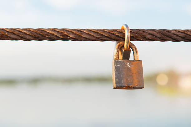 istock Old padlock lock on wire rope sling. 628907760