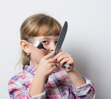 little girl with a knife and fork