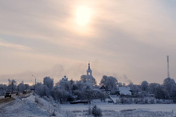 View on a village with church covered by snow on a frosty day over a small river, Porechye village, Nerl river, Tver region, Russia