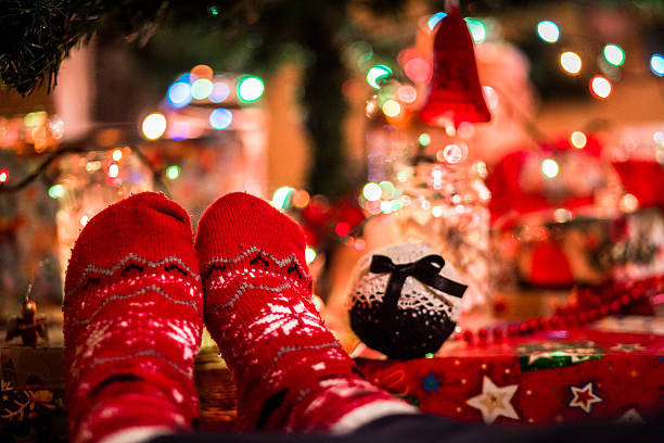 istock Feet wearing festive socks beneath illuminated Christmas tree 628915930
