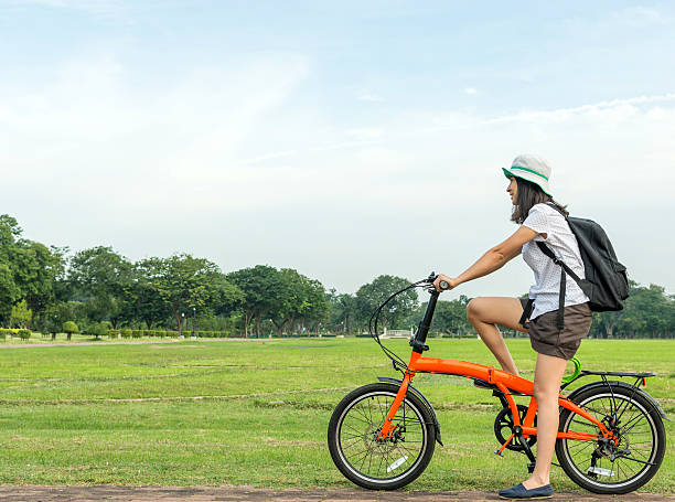 istock young hipster woman sit on roadside with bicycle 628923680