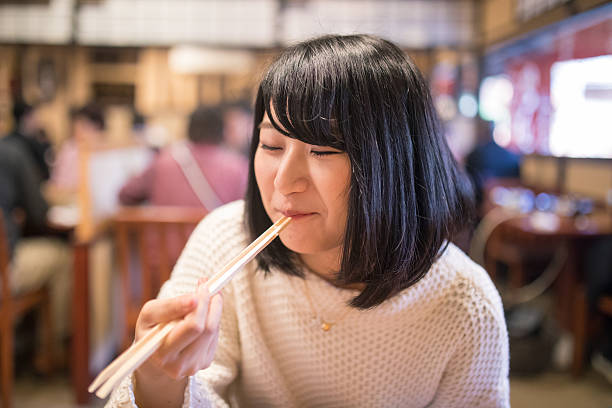 日本食を箸で食べる若い女性 - hashis ストックフォトと画像