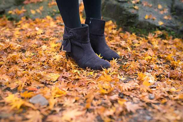 Woman standing on fallen autumn leaves