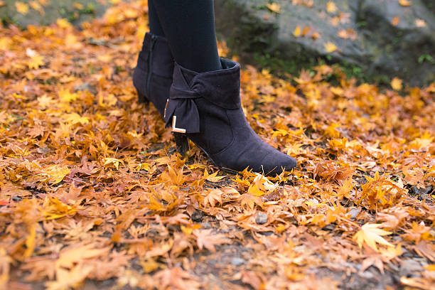 Woman walking on fallen autumn leaves