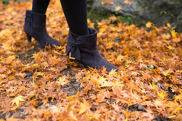 Woman walking on fallen autumn leaves