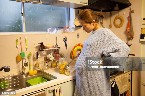 Pregnant Mother Making Drink With Her Daughter In Her Kitchen Stock Photo - Download Image Now