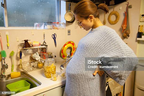Schwangere Mutter Macht Trinken Mit Ihrer Tochter In Ihrer Küche Stockfoto und mehr Bilder von Geburtsfest