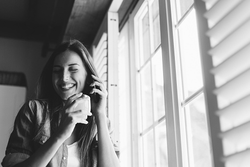 Young woman at home enjoying a conversation by the phone