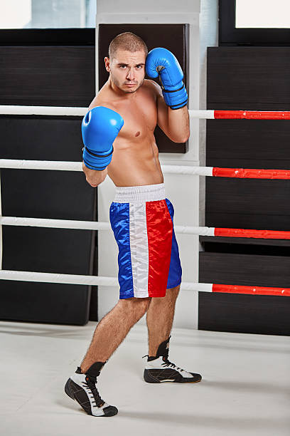 istock Boxer in blue gloves warming up in the ring 628942050