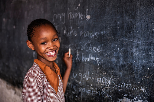 African little girl during her English class in orphanage. There is no light and electricity inside the classroom. Around 50-60 orphans live in this orphanage which is located near Nairobi.