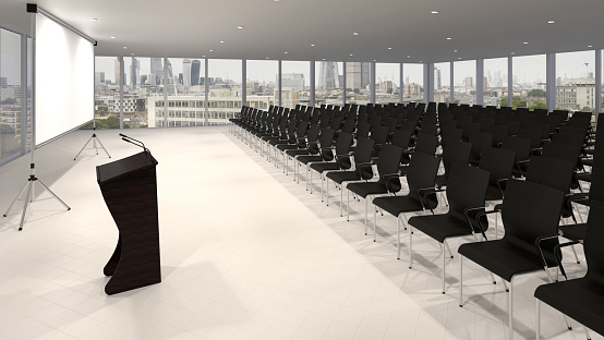 This photo captures the calm and orderly atmosphere of an empty conference room. The neatly arranged chairs and table, along with the specialized microphone with a curved handle for speaking, suggest that this is a professional setting where important decisions are made. This room is likely used for meetings, presentations, and other collaborative activities where ideas are exchanged and discussed. While the room may be empty now, it holds the promise of lively discussions and meaningful exchanges in the future.