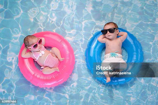 Baby Twin Boy And Girl Floating On Swim Rings Stock Photo - Download Image Now - Baby - Human Age, Swimming Pool, Summer