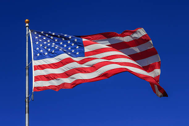 istock American flag waving in clear blue sky 628952006