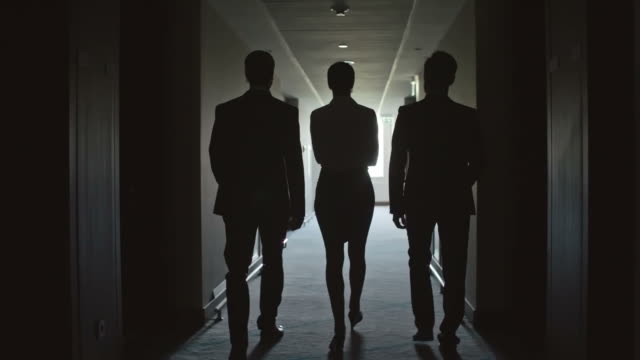 Business People Walking through Corridor in the Hotel