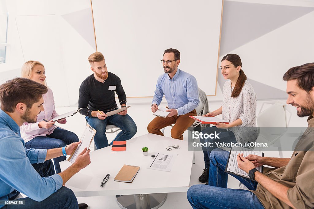 Lächelnde Menschen sitzen im Kreis - Lizenzfrei Spielen Stock-Foto