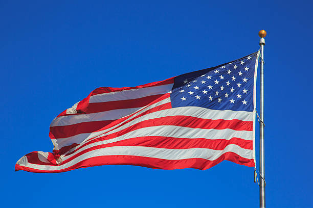 istock USA flag waving in clear sky 628963162