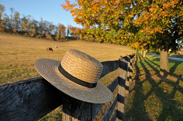 Amish Straw Hat in Pennsylvania Fall Closeup of traditional Amish straw hat in front of horse farm in the fall Amish stock pictures, royalty-free photos & images