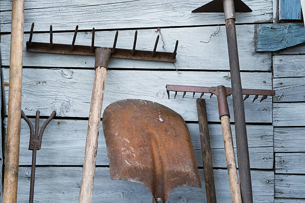 The old rusty tradition tools The old rusty tradition tools, instruments, implements and farm or household equipment on wooden shed wall background garden hoe photos stock pictures, royalty-free photos & images