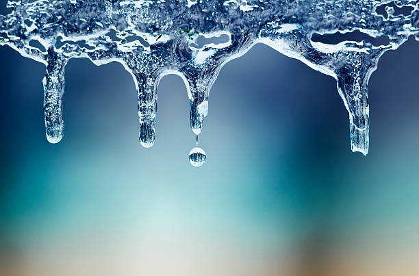 shiny clear ice icicles hang on a clear day shiny clear ice icicles hang on a clear day icicles melting stock pictures, royalty-free photos & images