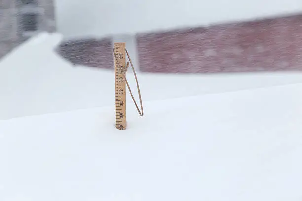 Wood yardstick measuring the depth of the snow in Winter.