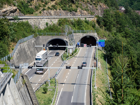 Amsteg, Switzerland - August 7, 2015: Tunnel entrance on the Gotthard highway A2 near Amsteg, one of the busiest alpine transit roads connecting Italy with nothern Europe via Switzerland.