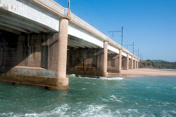 istock Concrete Bridge Extending Over River Mouth with Incoming Tide 628965936