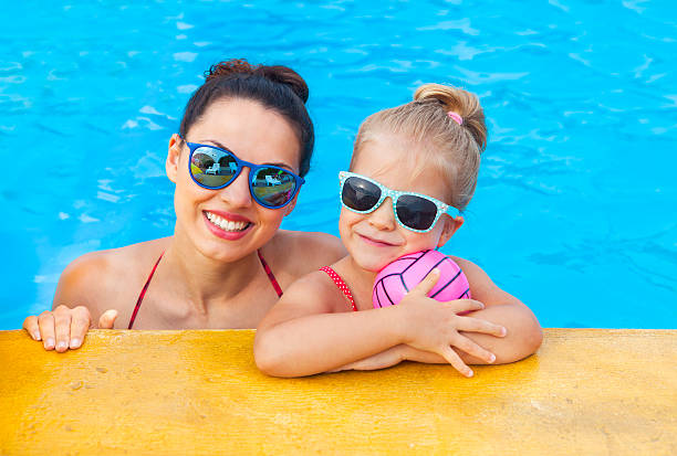 szczęśliwa matka i córeczka bawią się w basenie - fun mother sunglasses family zdjęcia i obrazy z banku zdjęć