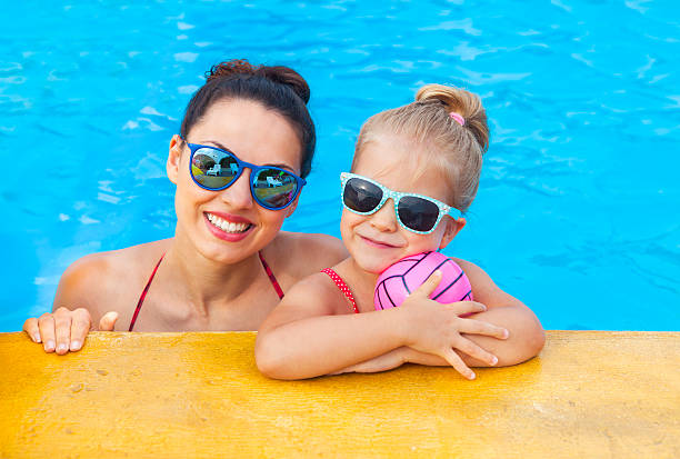 счастливая мать и маленькая дочь веселились в бассейне - fun mother sunglasses family стоковые фото и изображения