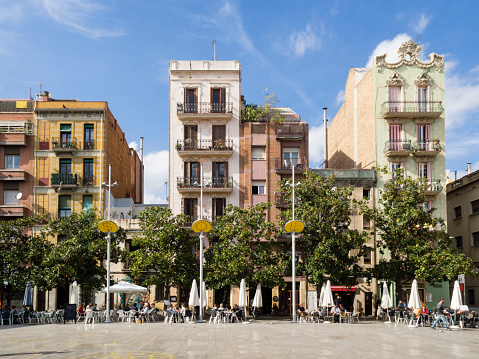 Barcelona, Spain - October 16, 2015: People are enjoying the autumn sun outside at the Placa del Sol in Barcelona's trendy Gracia residential district.