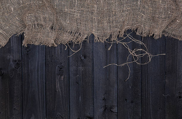 istock Dark wooden table background with burlap, top view 628967950