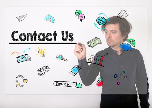 Contact Us concept. Businessman writing with black marker on visual screen