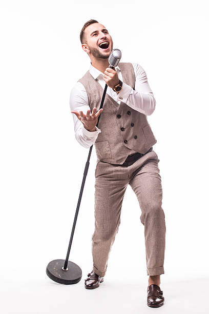 istock Young showman in suit singing  over the microphone 628978382