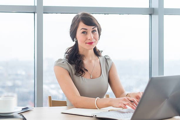 istock Beautiful female copywriter sitting in office, typing new article, working 628985262
