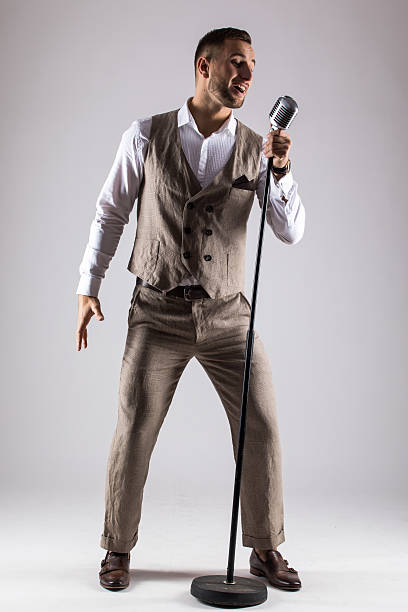 istock Silhouette of singer with microphone on grey background. Singer concept. 628985404