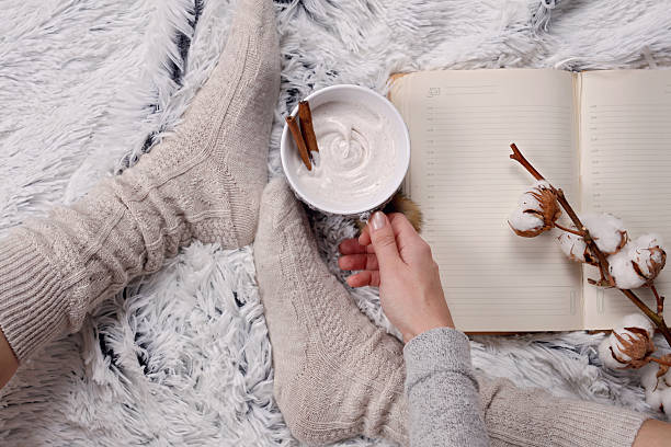 istock Woman wearing cozy warm wool socks, reading a book 628986270