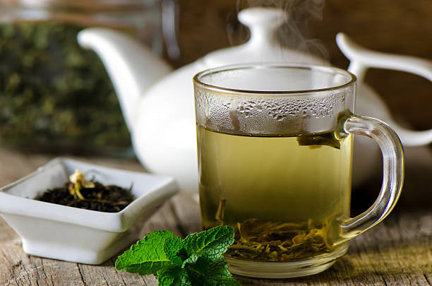 taza de vidrio con té verde fresco - te verde fotografías e imágenes de stock