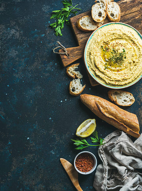 istock Homemade hummus dip with fresh baguette, lemon, herbs and spices 628987334
