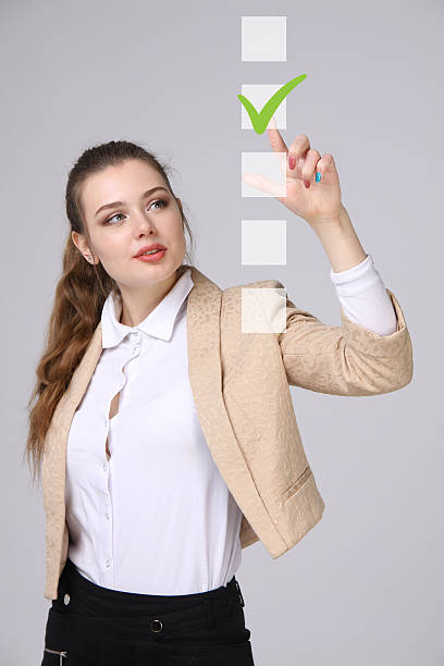 istock Young business woman checking on checklist box. Gray background. 628987832