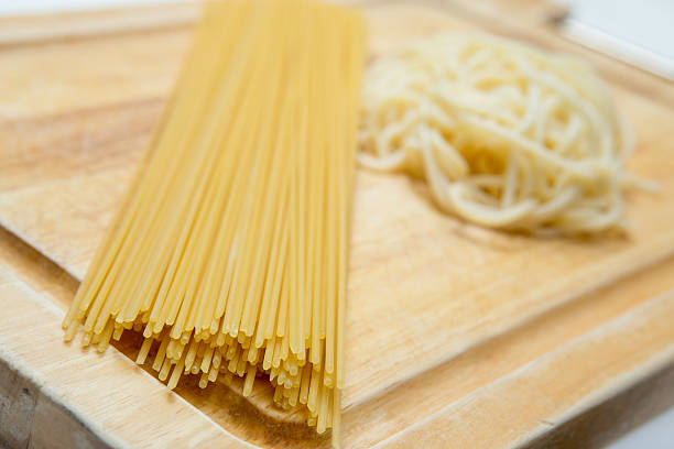 istock Raw Spaghetti and Boiled Spaghetti on wood board 628994196