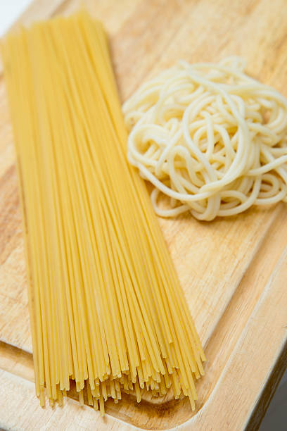 istock Raw Spaghetti and Boiled Spaghetti on wood board 628994280