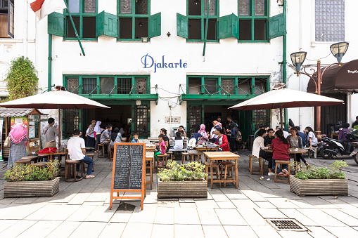Jakarta, Indonesia - October 9, 2016: People enjoy lunch in a restaurant terrace of an old Dutch colonial building in Jakarta old town (Kota Tua) near Fatahillah Square in Indonesia capital city.