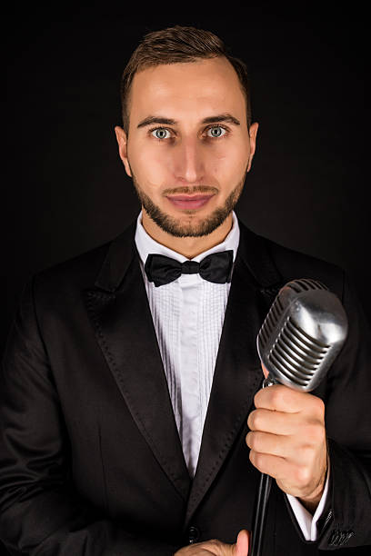 istock Portrait of handsome man sing on microphone on black background. 628994668