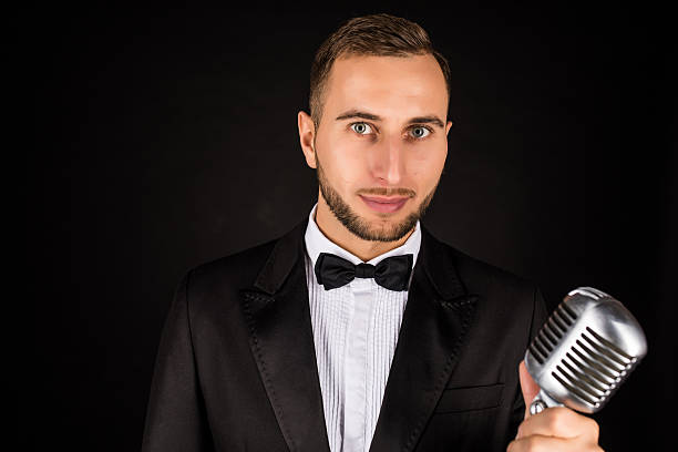 istock Portrait of handsome man sing on microphone on black background. 628994816