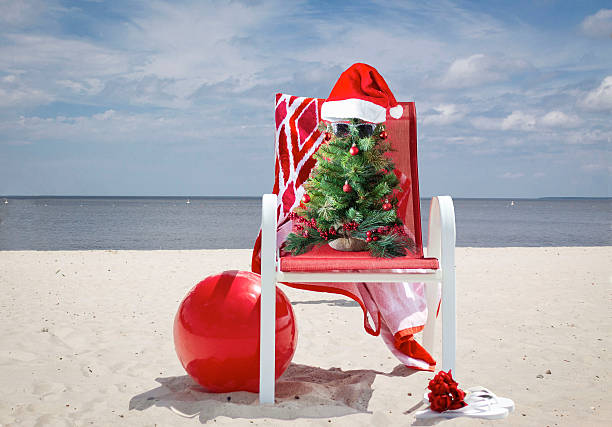 istock Christmas tree sitting in lawn chair at the beach. 628997024