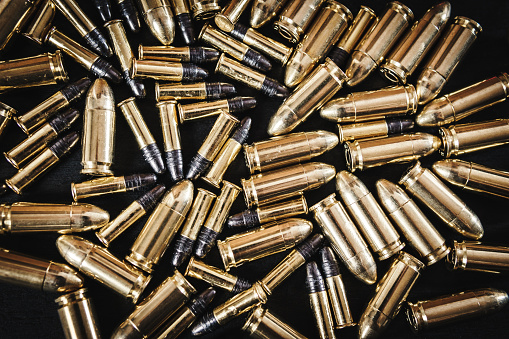 bullets from the gun placed on a black wooden table