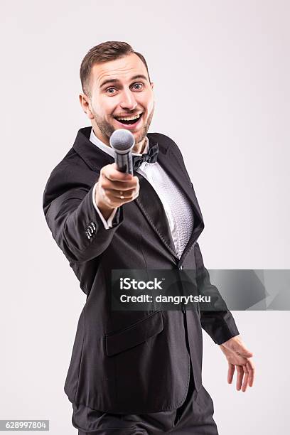 ショーマンのインタビュアー。マイクを持つ若いエレガントな男 - ストックフォト・写真素材...