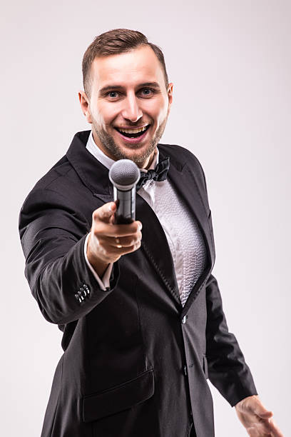 istock The Showman interviewer. Young elegant man holding microphone 628997862